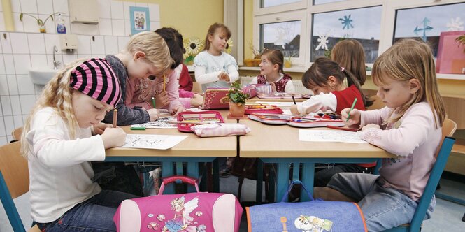 Mehrere Vorschulkinder sitzen an einem Tisch und malen