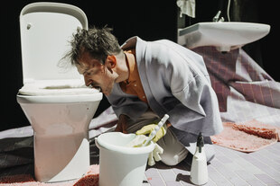 Der Musiker Max Andrzejewski beißt auf einer Bühne in eine mutmaßliche Klobrillenattrappe. Der Musiker Max Andrzejewski beißt auf einer Bühne in eine mutmaßliche Klobrillenattrappe.