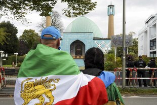 Mann und Frau mit der Flagge des Irans unter dem Schah vor der Blauen Moschee in Hamburg, dem ehemaligen Islamischen Zentrum.