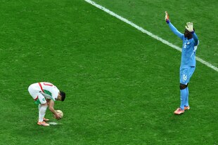 Brahim Díaz legt sich den Ball auf den Elfmeterpunkt, während Senegals Torhüter Edouard Osoque Mendy sich ihm mit erhobenen Armen nähert.