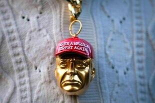 Eine Trumpfigur mit MAGA-Kappe als goldener Kettenanhänger