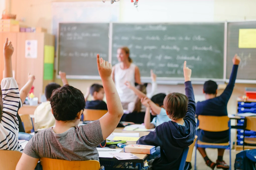 Schülerinnen, Schüler und eine Lehrerin in einem Klassenraum