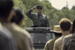 Mark Hamill steht in einem Majorkostüm mit dunkler Sonnenbrille vor jungen Männern.