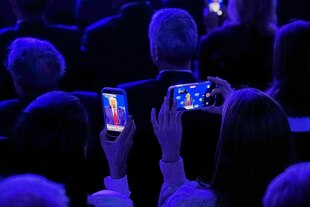 Menschen im Publikum fotografieren Donald Trump während seiner Rede auf dem Weltwirtschaftsforum mit ihren Handys