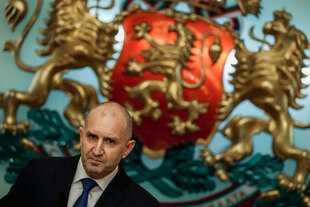 Ein Mann vor einem großen Wappen