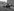 Ein historisches Foto zeigt eine Familie vor einem Trabant vor Wohnblöcken