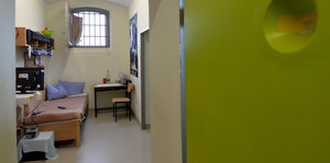 Blick durch die Tür in eine Gefängniszelle.