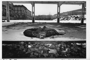 Schwarz-Weiß-Foto eines abgelegten Gedenkkranzes.