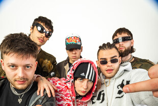 Das HipHop-Kollektiv Natura2000 mit einer Fischaugen-Perspektive aufgenommen. Vorne zeigen zwei garstige Rapper den Schweinefinger