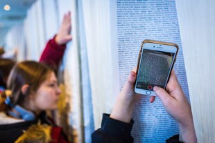 Besucher fotografieren Namen aus der Opferliste des Holocaust