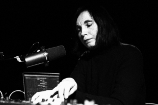 Svitlana Nianio sitzt an einem Synthesizer und singt in ein Mikro.