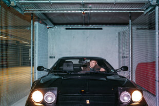 Ein Mann sitzt in einem Ferrari in einer Garage