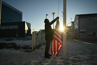 Ein Mann versucht eine amerikanische Flagge zu hissen
