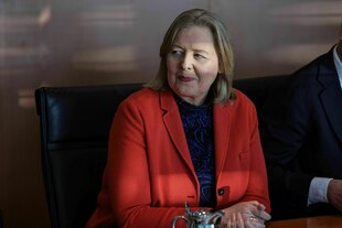 Eine Frau in roter Jacke schmunzelt