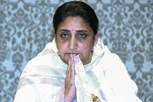 Eine Frau faltet die Hände vor ihrer Brust.