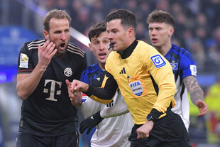 Ein Fußballspieler des FC Bayern beschwert sich beim Schiedsrichter.