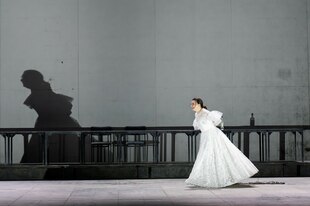 eine Frau in weißem Kleid auf der Bühne