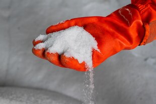 Ein Mitarbeiter hält auf einem Betriebshof der Berliner Stadtreinigung (BSR) Streusalz für den Winterdienst.