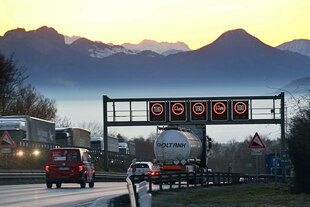 Eine Schilderbrücke auf der Autobahn zeigt Tempo 100 an.