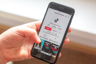 Eine Person hält ein Smartphone hält, auf dessen Display das TikTok-Profil von „Tiktok Deutschland“ mit über 2,9 Millionen Followern zu sehen ist.
