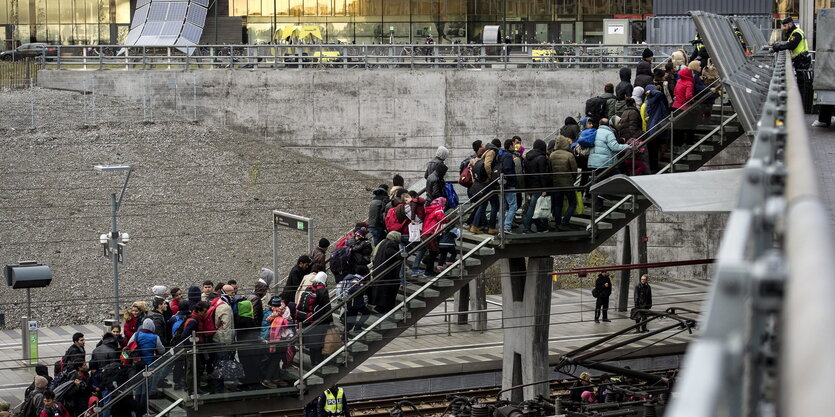 Flüchtlinge gehen in mehreren Reihen eine Treppe am Bahnhof von Malmö hinauf.