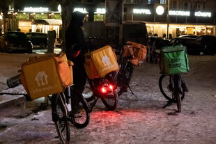 Fahrräder von Lieferservice Lieferando und Uber Eats im Schnee vor einem Restaurant in Berlin