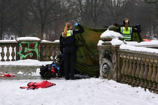 Polizistinnen stehen an einem Zelt auf einer Brücke