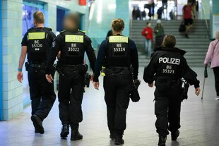 Polizeibeamte gehen durch den Bahnhof Alexanderplatz