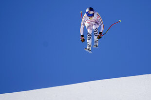 Eine Frau auf Skiern schwebt mindestens einen Meter über der Piste