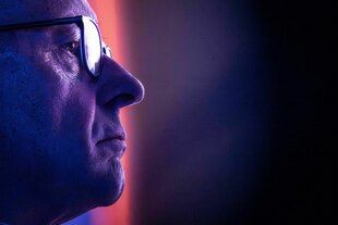 Nahaufnahme Merz, in lila Licht den Blick herablassend und kalt