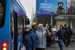 Menschen warten an einer Bushaltestelle in Moskau, im Hintergrund ein Werbeplakat mit einem Soldaten und der Aufschrift "Stolz Russlands" Menschen warten an einer Bushaltestelle in Moskau, im Hintergrund ein Werbeplakat mit einem Soldaten und der Aufschrift "Stolz Russlands"
