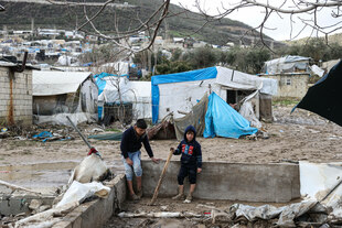 Kinder zwischen nassen Zelten