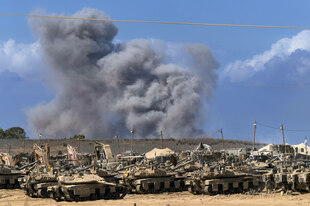 Israelische Panzer und Rauchwolke eines Luftangriffs