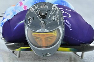 Wladyslaw Heraskewytsch auf seinem Schlitten mit Helm, auf dem die Portraits getöteter ukrainischer Sportler*innen abgebildet sind Wladyslaw Heraskewytsch auf seinem Schlitten mit Helm, auf dem die Portraits getöteter ukrainischer Sportler*innen abgebildet sind