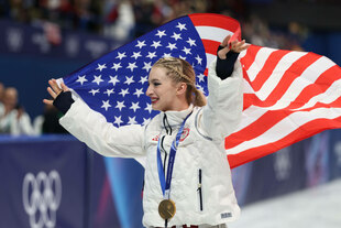 Amber Glenn mit der US-Fahne auf dem Eis Amber Glenn mit der US-Fahne auf dem Eis