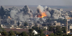 Bomben explodieren in einer syrieschen Ruinenstadt.