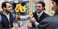 Syrische Flüchtlinge bedanken sich bei PassantInnen in Dresden für ihre Aufnahme mit Blumen.
