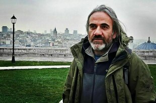 Ein Mann mit Bart vor einer Stadt Ein Mann mit Bart vor einer Stadt