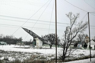 Ein als Denkmal genutztes Flugzeug ist durch ein Anti-Drohnennetz zu sehen, das die Straße zum Schutz vor russischen FPV-Drohnenangriffen bedeckt Ein als Denkmal genutztes Flugzeug ist durch ein Anti-Drohnennetz zu sehen, das die Straße zum Schutz vor russischen FPV-Drohnenangriffen bedeckt