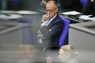 Merz schaut skeptisch während Weidel spricht