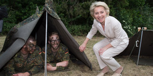 Ursula von der Leyen und zwei Soldaten in einem Zelt
