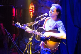 Sänger Kaan Tangöze bei einem Konzert mit Gitarre Sänger Kaan Tangöze bei einem Konzert mit Gitarre