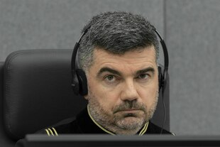 Ein Mann trägt Kopfhörer und schaut ernst Ein Mann trägt Kopfhörer und schaut ernst