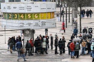 Menschen passieren die Weltzeituhr auf dem Alexanderplatz
