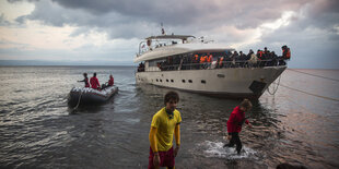 Ein Boot mit Menschen, nahe eines Ufers.