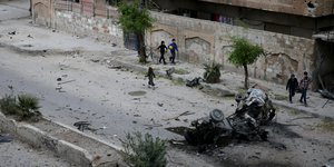 Menschen laufen durch zerstörte Straßen in Damaskus.