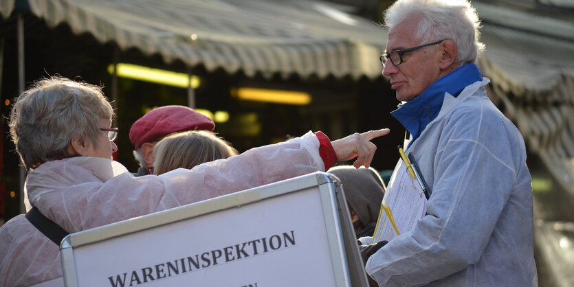 Protestierer in weiß vor Hinweistafel