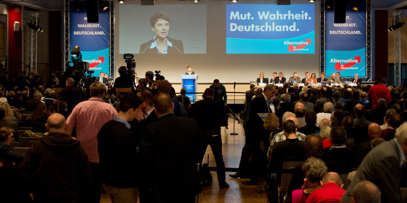 Menschen schauen auf ein Podium, auf dem Frauke Petry steht