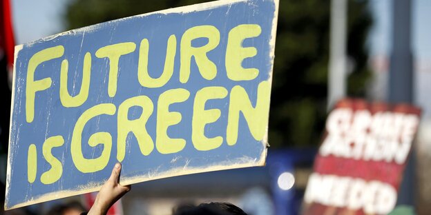 Ein blaues Schild mit in gelb geschriebenem Spruch: „Future is Green"
