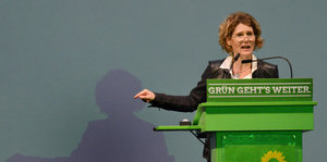 Die Spitzenkandidatin der Grünen, Eveline Lemke, steht hinter einem grünen Pult und zeigt in die Gegend